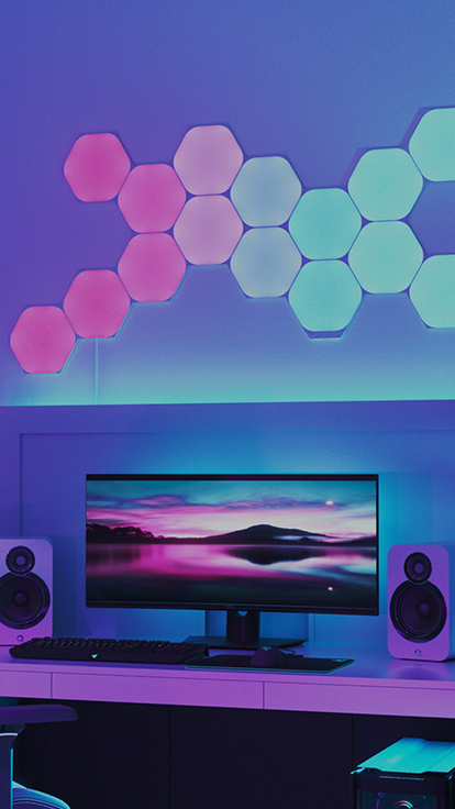 Questa è un’immagine dei pannelli Nanoleaf Shapes Hexagons su una parete al di sopra di un monitor posizionato su una scrivania. Si tratta di luci RGB perfette per il giocatore di casa. I pannelli luminosi colorati e modulari sono collegati tramite connettori e dispongono di oltre 16 milioni di colori.