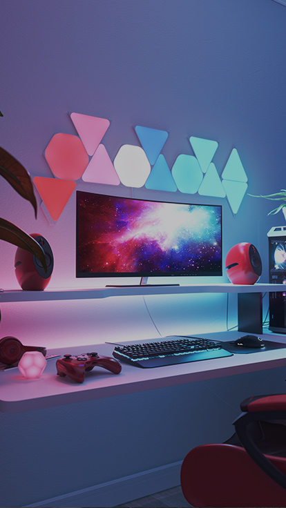 Dies ist ein Bild eines Nanoleaf Shapes Light Panels in einem Gaming-Zimmer. Es sind RGB-Leuchten, die optimal für den Gamer daheim sind. Die modularen, farbwechselnden Light Panels lassen sich miteinander verbinden, um ein Design mit Hexagons und Triangles direkt über dem Monitor zu kreieren.