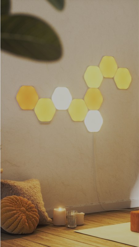 L’image représente une mise en forme réalisée à l’aide de neuf panneaux Hexagones Nanoleaf Shapes agrémentant une salle de méditation. Les lumières RVB sont parfaites pour se détendre ou trouver l’inspiration.