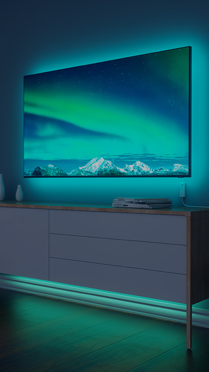Dies ist ein Bild der Nanoleaf Essentials Lightstrips hinter einem Fernsehgerät im Wohnzimmer. Die farbwechselnden Lightstrips sorgen für eine schöne Hintergrundbeleuchtung und einen angenehmen RGB-Lichtschein.