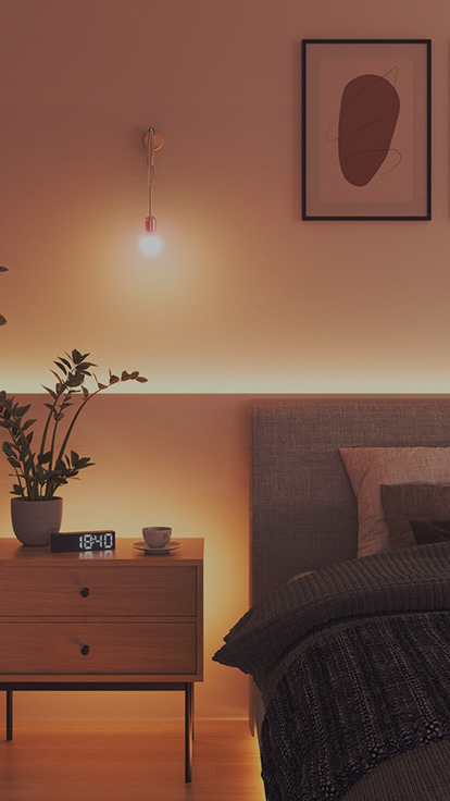 Dies ist ein Bild der Nanoleaf Essentials Glühbirne in einem Schlafzimmer. Der Leuchtkörper befindet sich an der Wand zwischen dem Bett und dem Nachttisch und ist das perfekte Schlafzimmerlicht zur Schaffung der perfekten Atmosphäre.