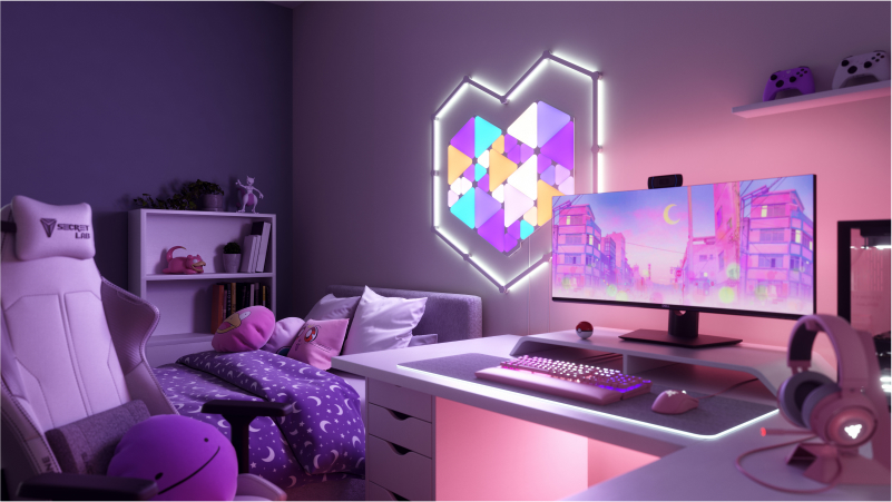 Dies ist ein Bild der Nanoleaf Shapes Triangles und Mini Triangles an der Wand über dem Schreibtisch und hinter dem Monitor einer Gaming-Battlestation. Diese RGB-Lichter verfügen über 16 Mio. Farben und sind perfekt für den Gamer daheim. Die modularen, intelligenten Light Panels werden mithilfe von Verbindungsstücken miteinander verbunden, um ein Design zu erschaffen.