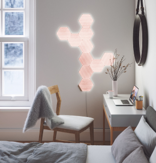 Dies ist ein Bild eines Layouts aus Nanoleaf Elements mit 10 Panels an einer Schlafzimmerwand neben einem Schreibtisch. Diese intelligenten Lichtpanels schaffen geometrisches Wand-Dekor, das in einem dynamischen Licht erstrahlt. Modulare intelligente Leuchten sind mit Verbindungsstücken miteinander verbunden und perfekt für kleine Räume.