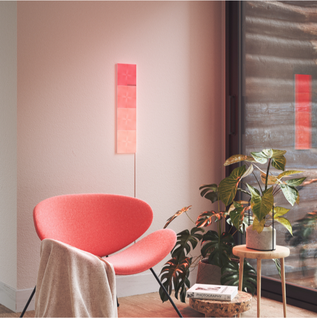 Panneaux lumineux modulaires intelligents carrés à couleurs changeantes Nanoleaf Canvas montés sur un mur dans une salle de séjour. Semblables à Philips Hue, Lifx. HomeKit, Assistant Google, Amazon Alexa, IFTTT. 