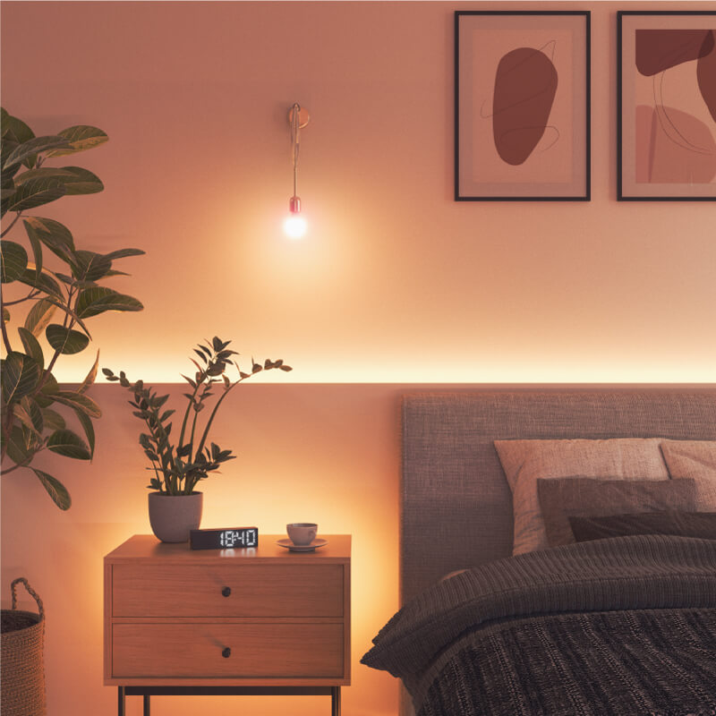 Nanoleaf Essentials, Thread-kompatible, farbwechselnde, intelligente Glühbirne in einer Fassung in einem Schlafzimmer. Ähnlich wie Wyze. HomeKit, Google Assistant, Amazon Alexa, IFTTT.