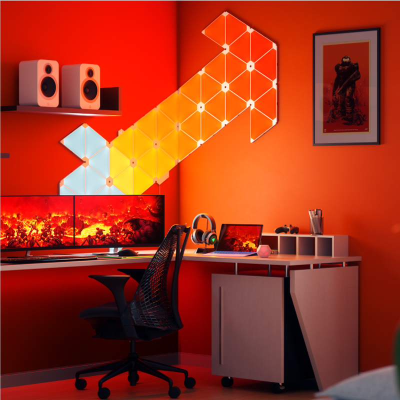 Pannelli luminosi triangolari smart modulari che cambiano colore Nanoleaf montati su un muro in una stanza per il gaming. Simile a Philips Hue, Lifx. HomeKit, Google Assistant, Amazon Alexa, IFTTT. 