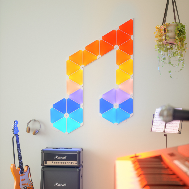 Pannelli luminosi triangolari smart modulari che cambiano colore Nanoleaf montati su un muro in una stanza per la musica. Simile a Philips Hue, Lifx. HomeKit, Google Assistant, Amazon Alexa, IFTTT.