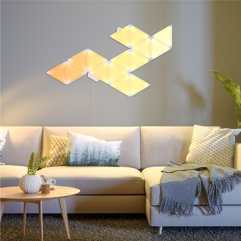 Pannelli luminosi triangolari smart modulari che cambiano colore Nanoleaf montati sul muro di un salotto. Simile a Philips Hue, Lifx. HomeKit, Assistente Google, Alexa di Amazon, IFTTT. 