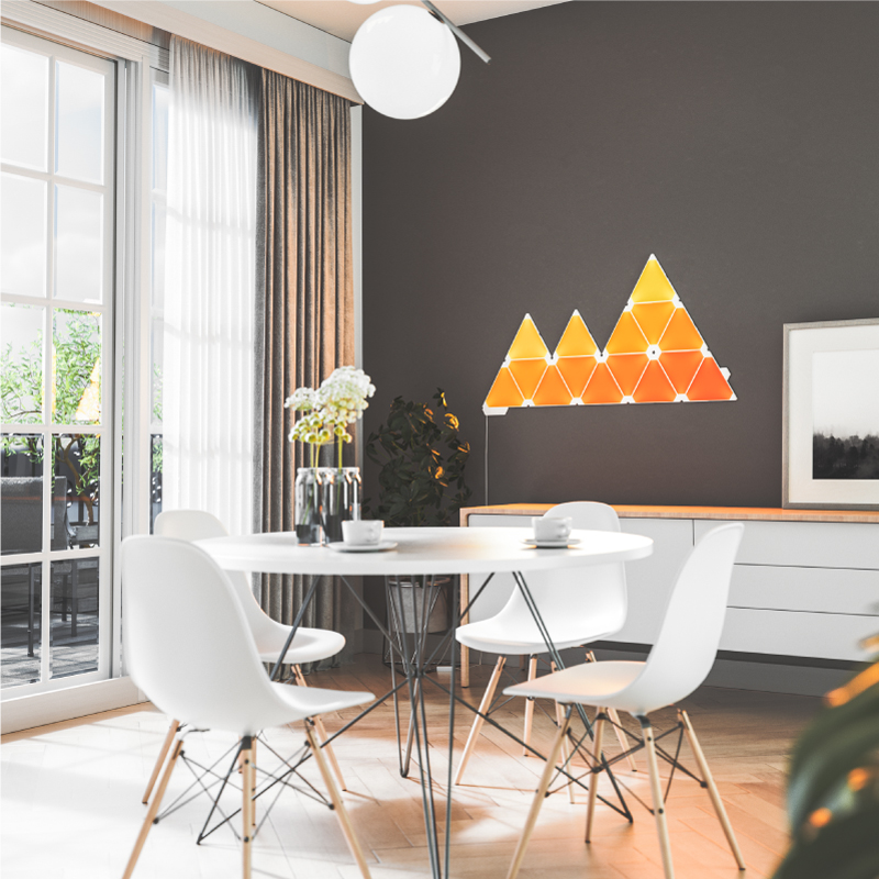 Pannelli luminosi triangolari smart modulari che cambiano colore Nanoleaf montati su un muro in una sala da pranzo. Simile a Philips Hue, Lifx. HomeKit, Google Assistant, Amazon Alexa, IFTTT.