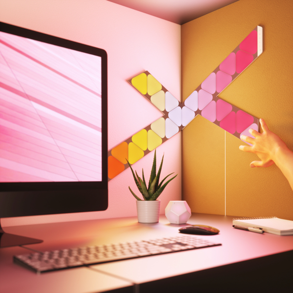 Nanoleaf Shapes Thread enabled color changing smart modular light panels flex linkers mounted to a wall in a home office. Similar to Philips Hue, Lifx. HomeKit, Google Assistant, Amazon Alexa, IFTTT.