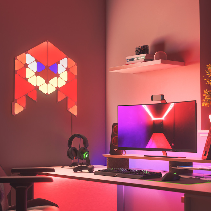 Nanoleaf Shapes Thread enabled color changing triangle and mini triangle smart modular light panels mounted to a wall above a battlestation as Knuckles. Sonic the Hedgehog 2. Similar to Philips Hue, Lifx. HomeKit, Google Assistant, Amazon Alexa, IFTTT.