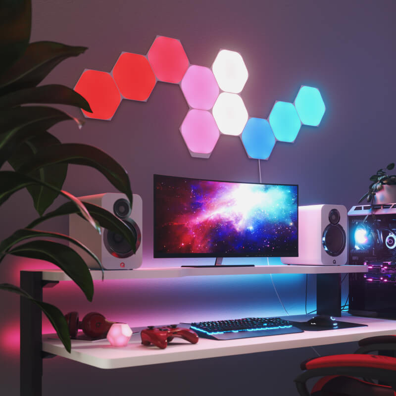 Nanoleaf Shapes Thread enabled color changing hexagon smart modular light panels mounted to a wall above a battlestation. Similar to Philips Hue, Lifx. HomeKit, Google Assistant, Amazon Alexa, IFTTT.