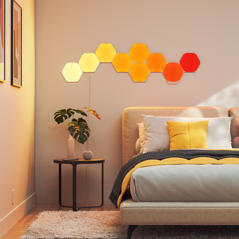 Panneaux lumineux modulaires intelligents hexagonaux Nanoleaf Elements compatibles Thread montés sur un mur dans une chambre à coucher. Semblables à Philips Hue, Lifx. HomeKit, Assistant Google, Amazon Alexa, IFTTT.