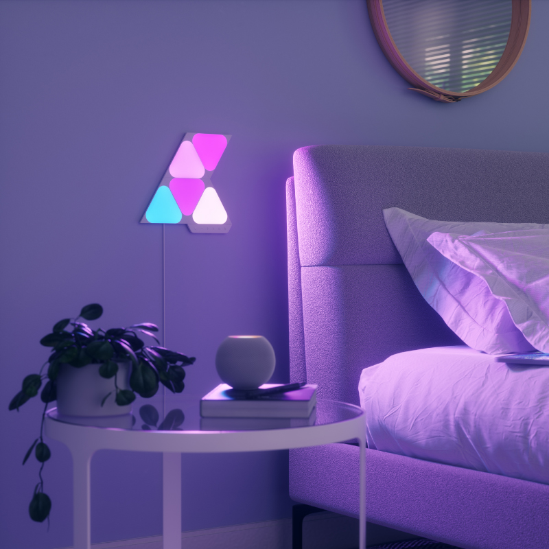 Nanoleaf Shapes, Thread-kompatible, farbwechselnde, intelligente, modulare, kleine dreieckige Lichtpanels an einer Schlafzimmerwand. Ähnlich wie Philips Hue, Lifx. HomeKit, Google Assistant, Amazon Alexa, IFTTT.