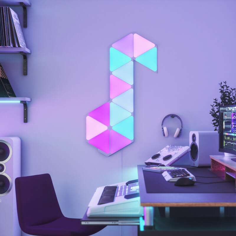 Panneaux lumineux modulaires intelligents triangulaires à couleurs changeantes Nanoleaf Shapes compatibles Thread montés sur un mur dans une salle de musique. Semblables à Philips Hue, Lifx. HomeKit, Assistant Google, Amazon Alexa, IFTTT.