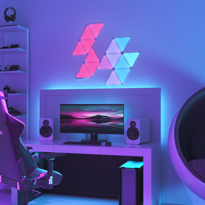 Nanoleaf Shapes Thread enabled color changing triangle smart modular light panels mounted to a wall above a battlestation. Similar to Philips Hue, Lifx. HomeKit, Google Assistant, Amazon Alexa, IFTTT.
