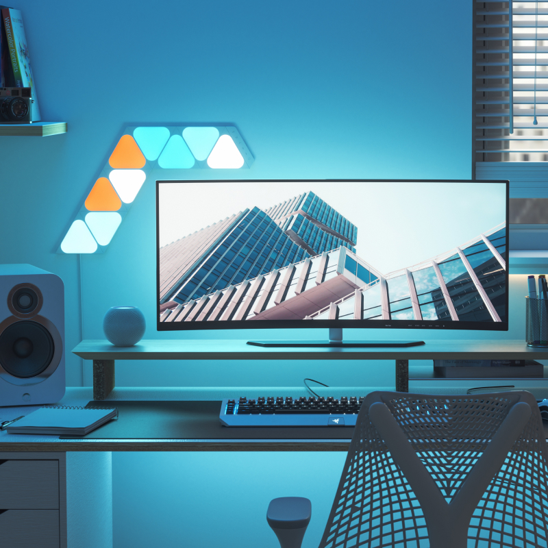 Work from home desk setup with 9 Nanoleaf Shapes Mini Triangle light panels mounted above and around the PC monitor. The perfect smart lights for your office.